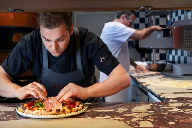 Chef bereidt pizza voor met Foster apparatuur